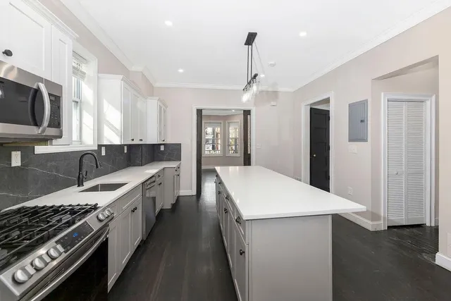 a kitchen with stainless steel appliances a sink stove and cabinets