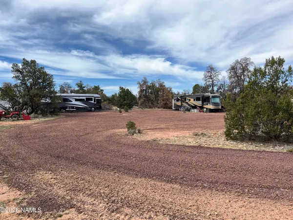 a view of dirt yard with a car parked