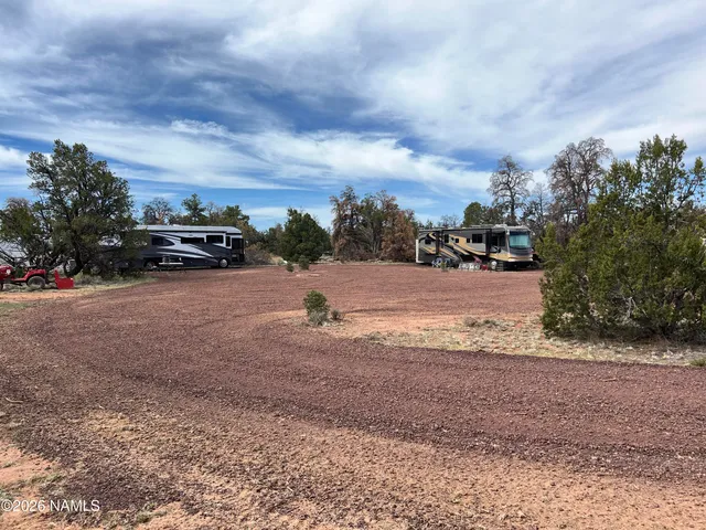 a view of dirt yard with a car parked