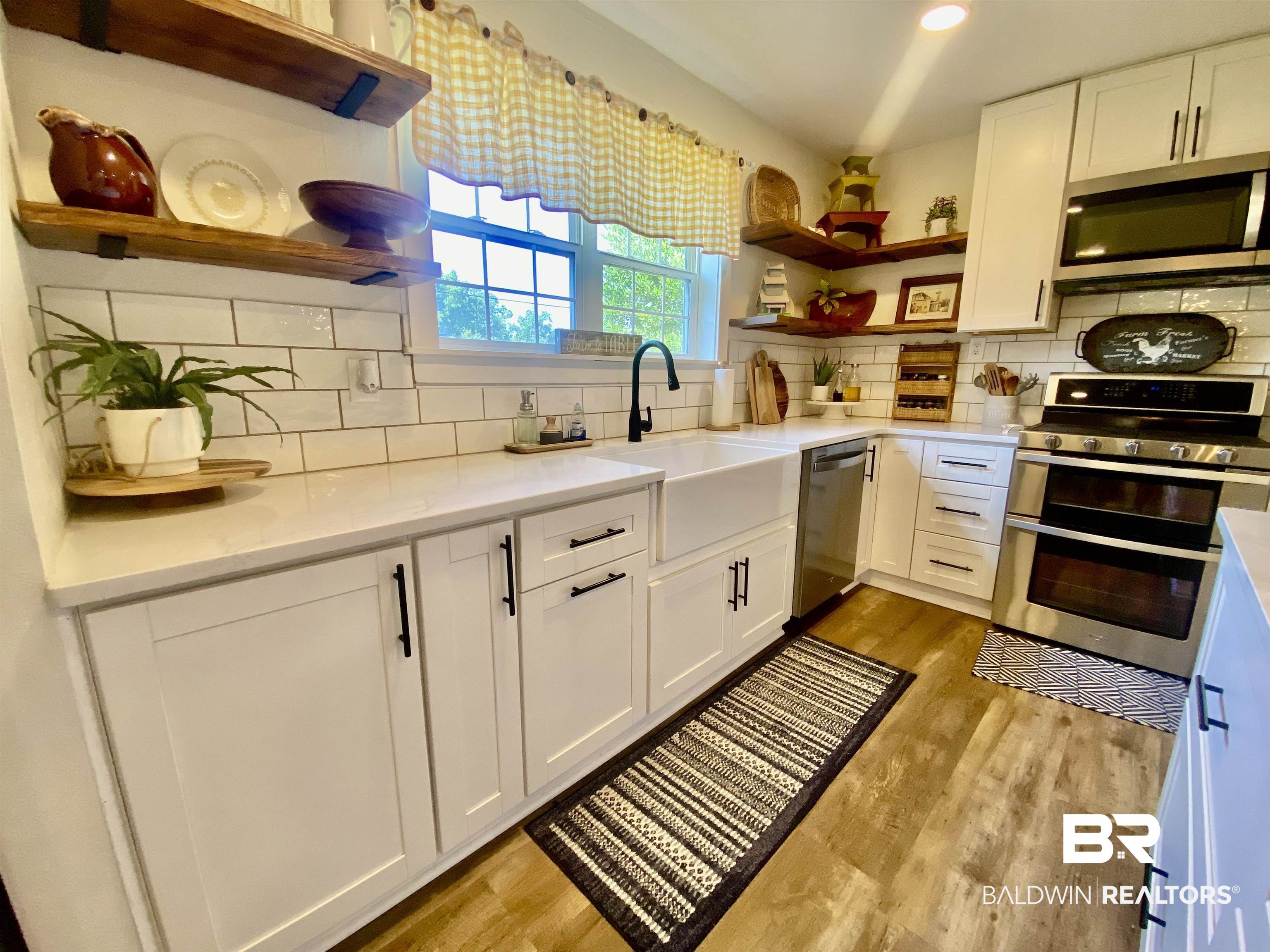 531 Highway 136 Monroeville, AL 36460 - Photo 14 of 48 Kitchen featuring light hardwood / wood-style floors, white cabinetry, backsplash, and stainless steel appliances