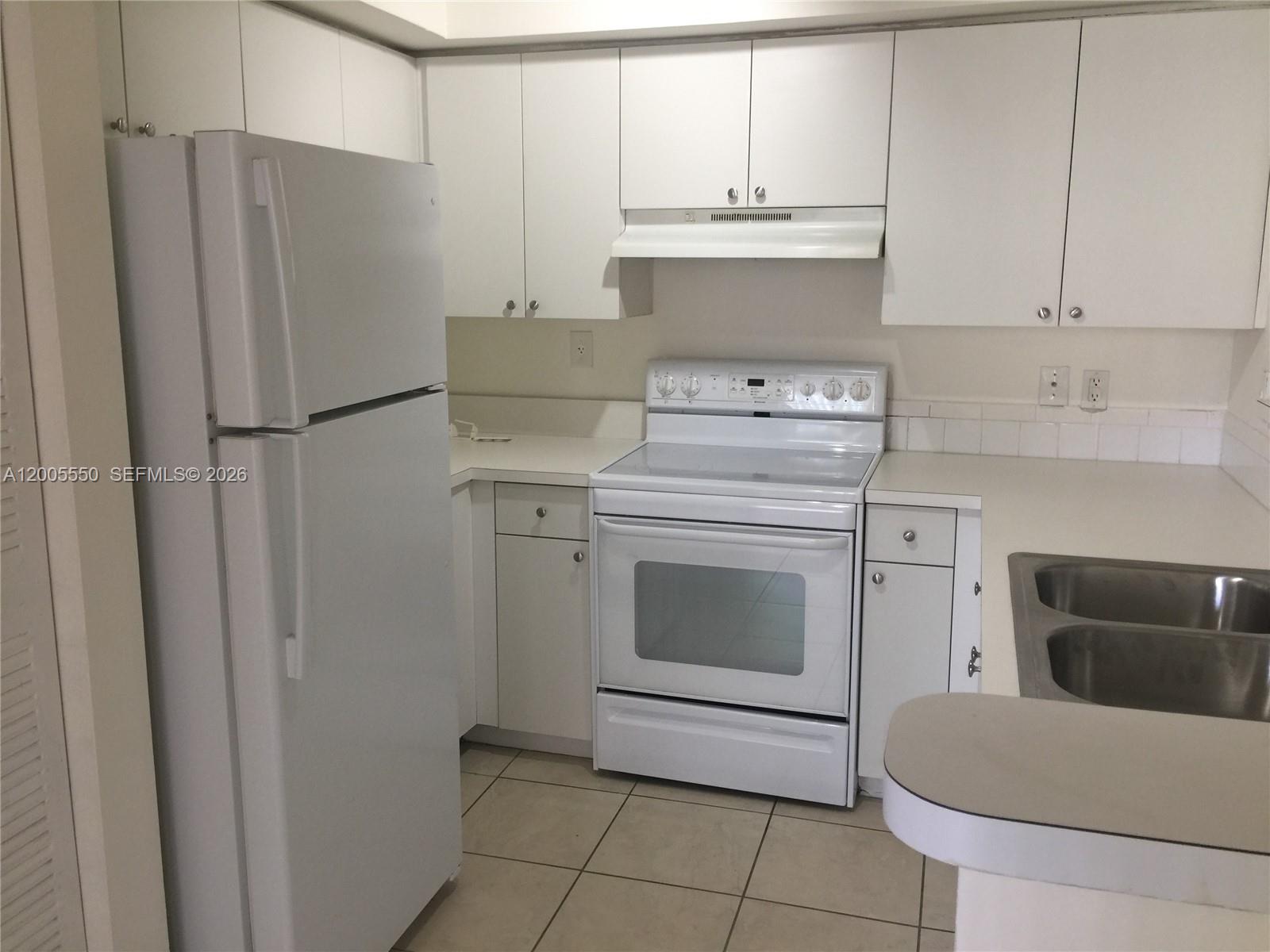 2103 Renaissance Boulevard, Unit 104 Miramar, FL 33025 - Photo 4 of 12 a kitchen with a stove top oven and cabinets