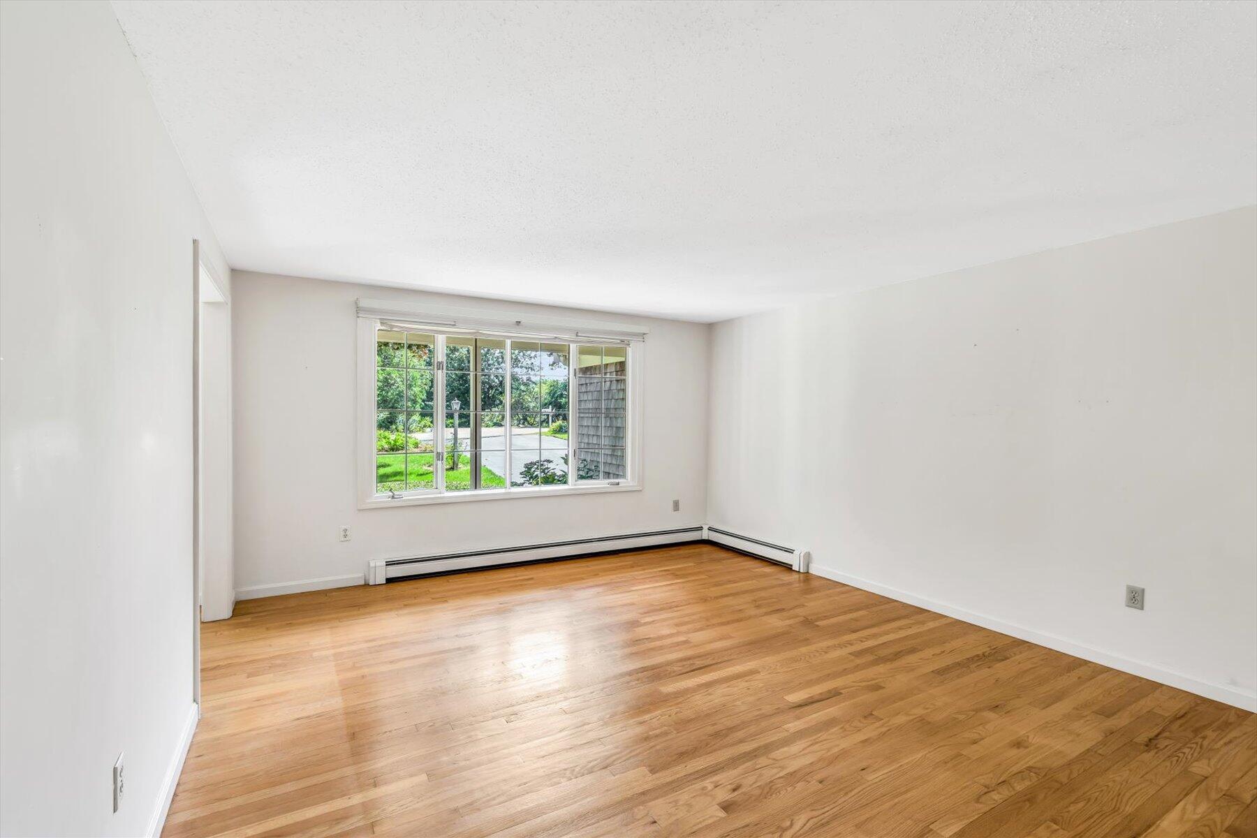 97 Headwaters Road Centerville, MA 02632 - Photo 7 of 44 an empty room with wooden floor and windows