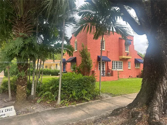 a view of a house with a yard and potted plants