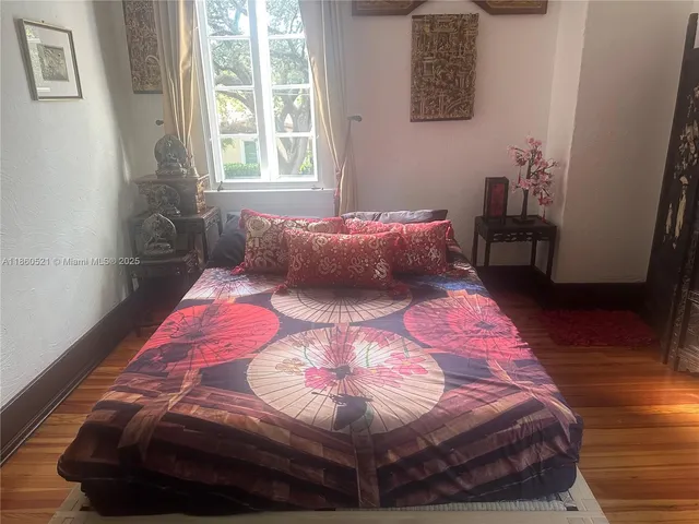 a large bed sitting in a bedroom next to a window