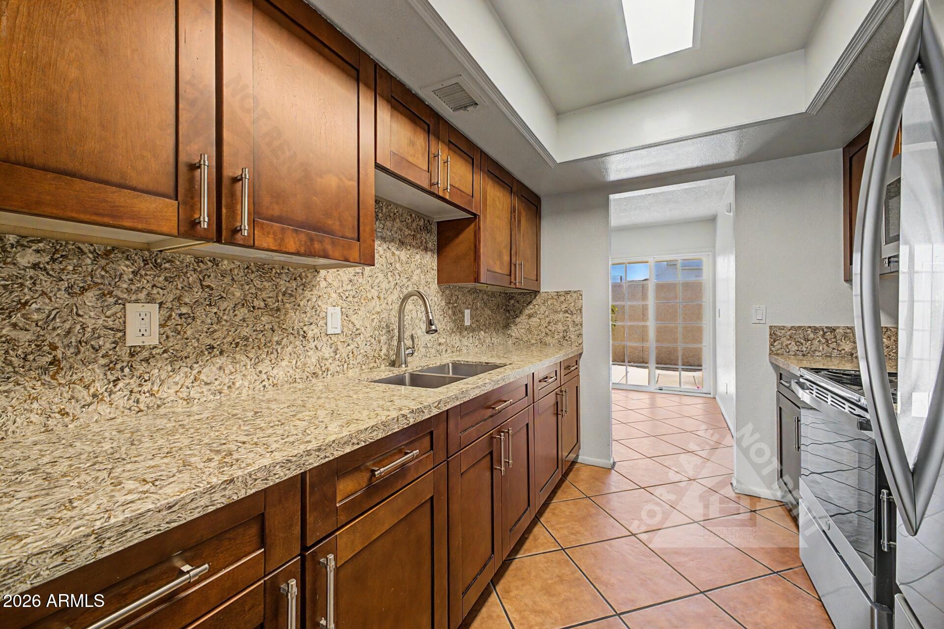 912 East Villa Rita Drive Phoenix, AZ 85022 - Photo 2 of 27 a kitchen with stainless steel appliances granite countertop a sink stove and cabinets