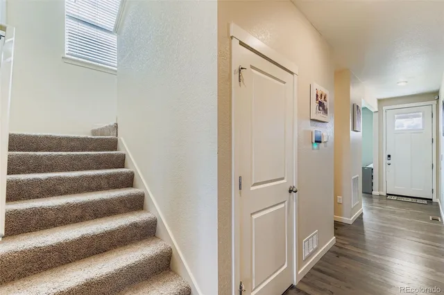 a view of a hallway with wooden floor and entryway