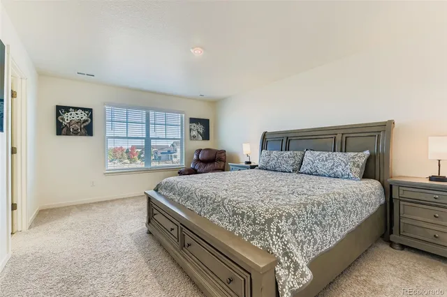 a bed sitting in a spacious bedroom next to a window