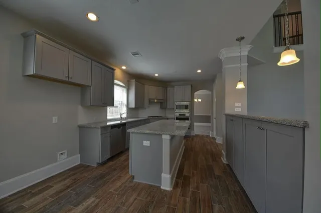 a kitchen with stainless steel appliances granite countertop a stove a sink and a refrigerator