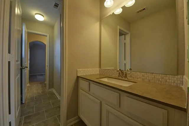 a bathroom with a granite countertop sink and a mirror