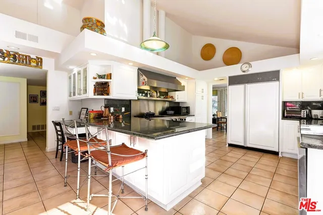 a kitchen with stainless steel appliances kitchen island granite countertop a table and chairs in it