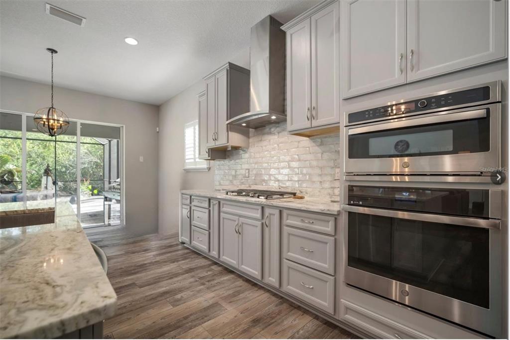 7004 Mainland Avenue Apollo Beach, FL 33572 - Photo 17 of 67 a kitchen with stainless steel appliances white cabinets and a stove top oven
