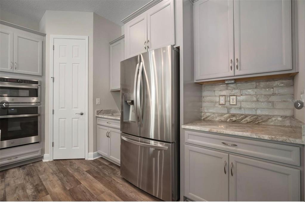 7004 Mainland Avenue Apollo Beach, FL 33572 - Photo 19 of 67 a kitchen with stainless steel appliances granite countertop a refrigerator sink and cabinets