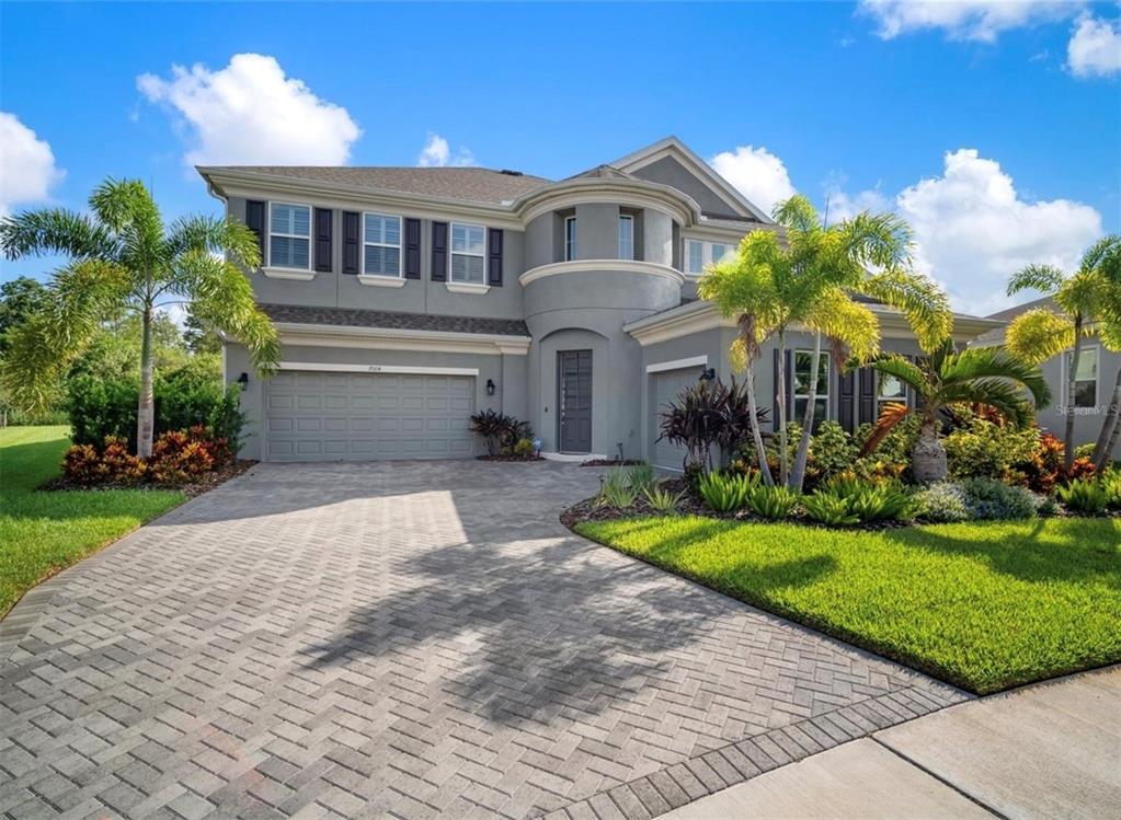 7004 Mainland Avenue Apollo Beach, FL 33572 - Photo 2 of 67 a front view of a house with a yard and potted plants