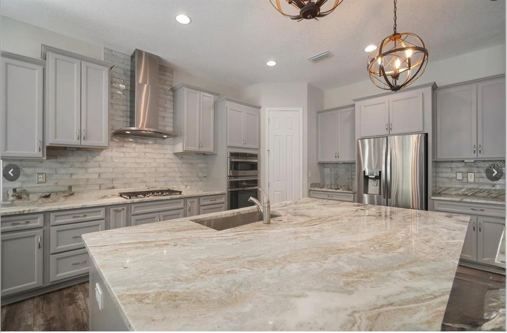 7004 Mainland Avenue Apollo Beach, FL 33572 - Photo 21 of 67 a large kitchen with cabinets and stainless steel appliances