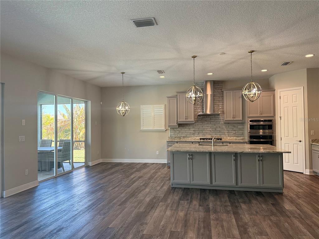 7004 Mainland Avenue Apollo Beach, FL 33572 - Photo 28 of 67 a large kitchen with cabinets wooden floor and stainless steel appliances