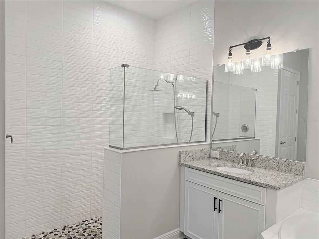 7004 Mainland Avenue Apollo Beach, FL 33572 - Photo 38 of 67 a bathroom with a granite countertop sink mirror and a shower