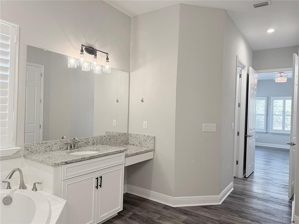 7004 Mainland Avenue Apollo Beach, FL 33572 - Photo 39 of 67 a bathroom with a granite countertop sink a mirror and shower