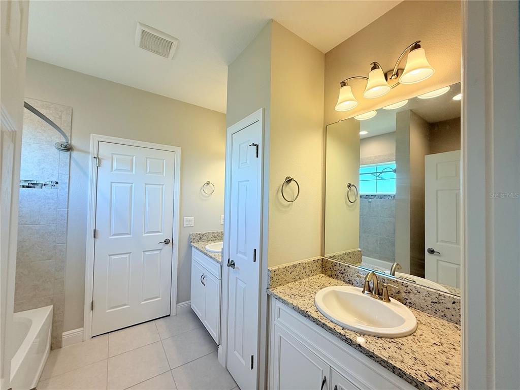 7004 Mainland Avenue Apollo Beach, FL 33572 - Photo 55 of 67 a bathroom with a granite countertop sink and a mirror