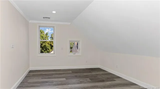 an empty room with wooden floor and window