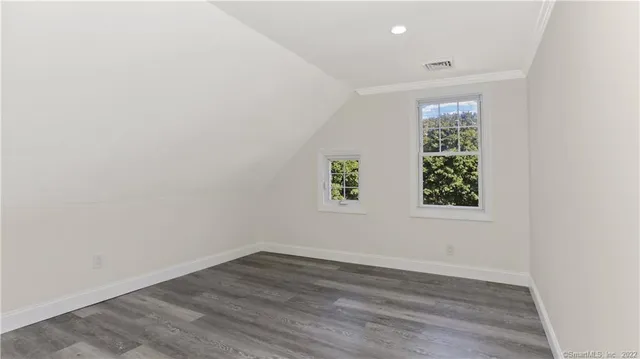 an empty room with wooden floor and window