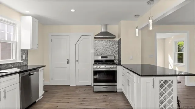 a kitchen with granite countertop a sink stove and refrigerator