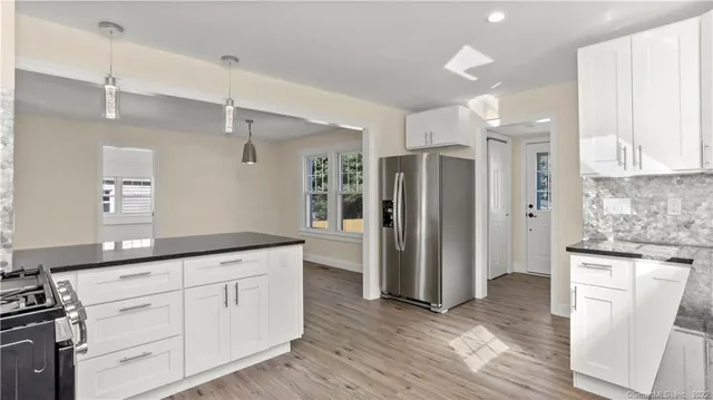 a kitchen with white cabinets and stainless steel appliances