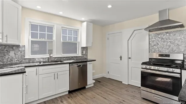 a kitchen with granite countertop cabinets stainless steel appliances and a sink