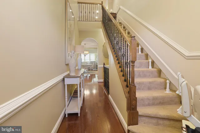 a kitchen with stainless steel appliances granite countertop a stove refrigerator a dining table and chairs with wooden floor