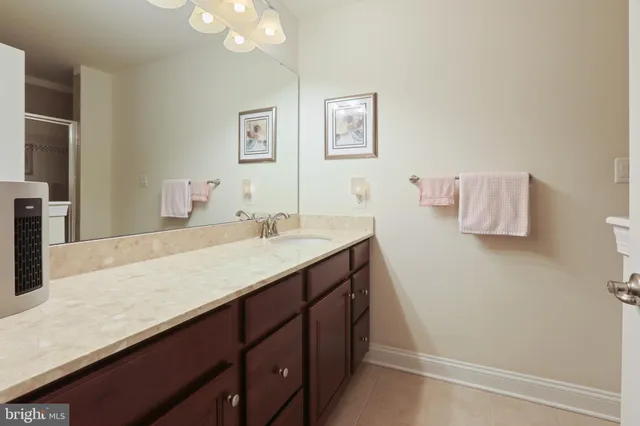 a bathroom with a granite countertop sink a toilet and a mirror