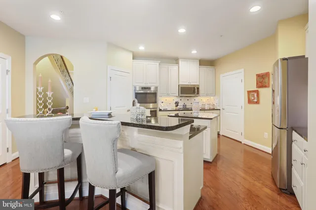 a kitchen with stainless steel appliances granite countertop a sink stove and cabinets