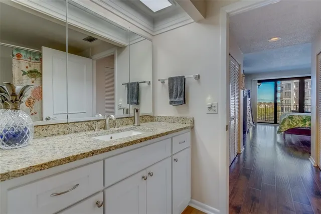 a bathroom with a granite countertop sink a mirror and shower