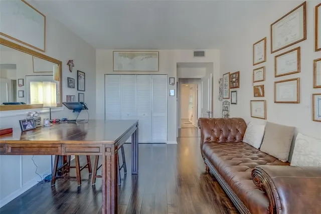 a view of a hallway with wooden floor and closet area