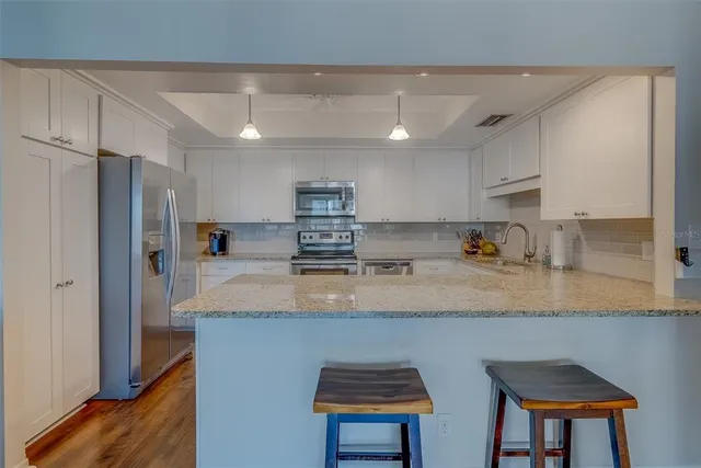 a kitchen with stainless steel appliances granite countertop a sink refrigerator and cabinets