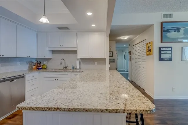 a kitchen with a sink dishwasher and cabinets