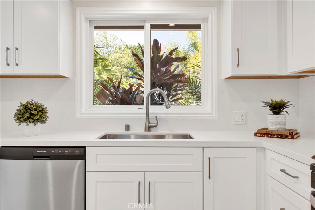 a sink with a window and cabinets