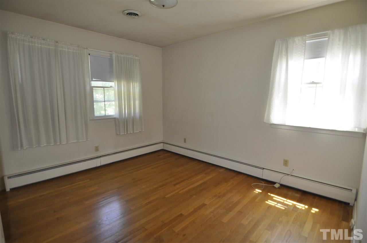 532 Princeton Street Raleigh, NC 27609 - Photo 16 of 19 a view of an empty room with wooden floor and a window