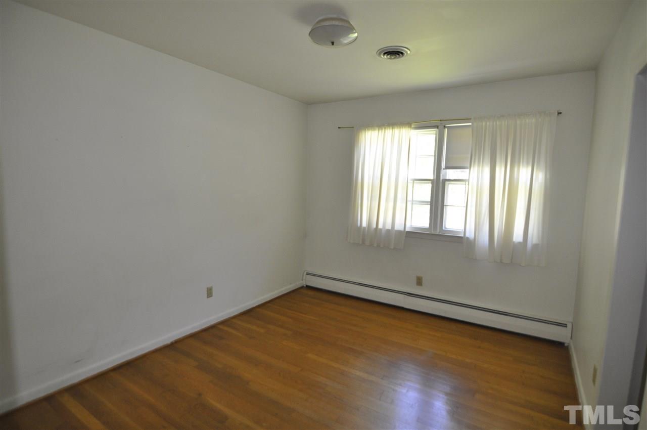 532 Princeton Street Raleigh, NC 27609 - Photo 17 of 19 an empty room with wooden floor and windows