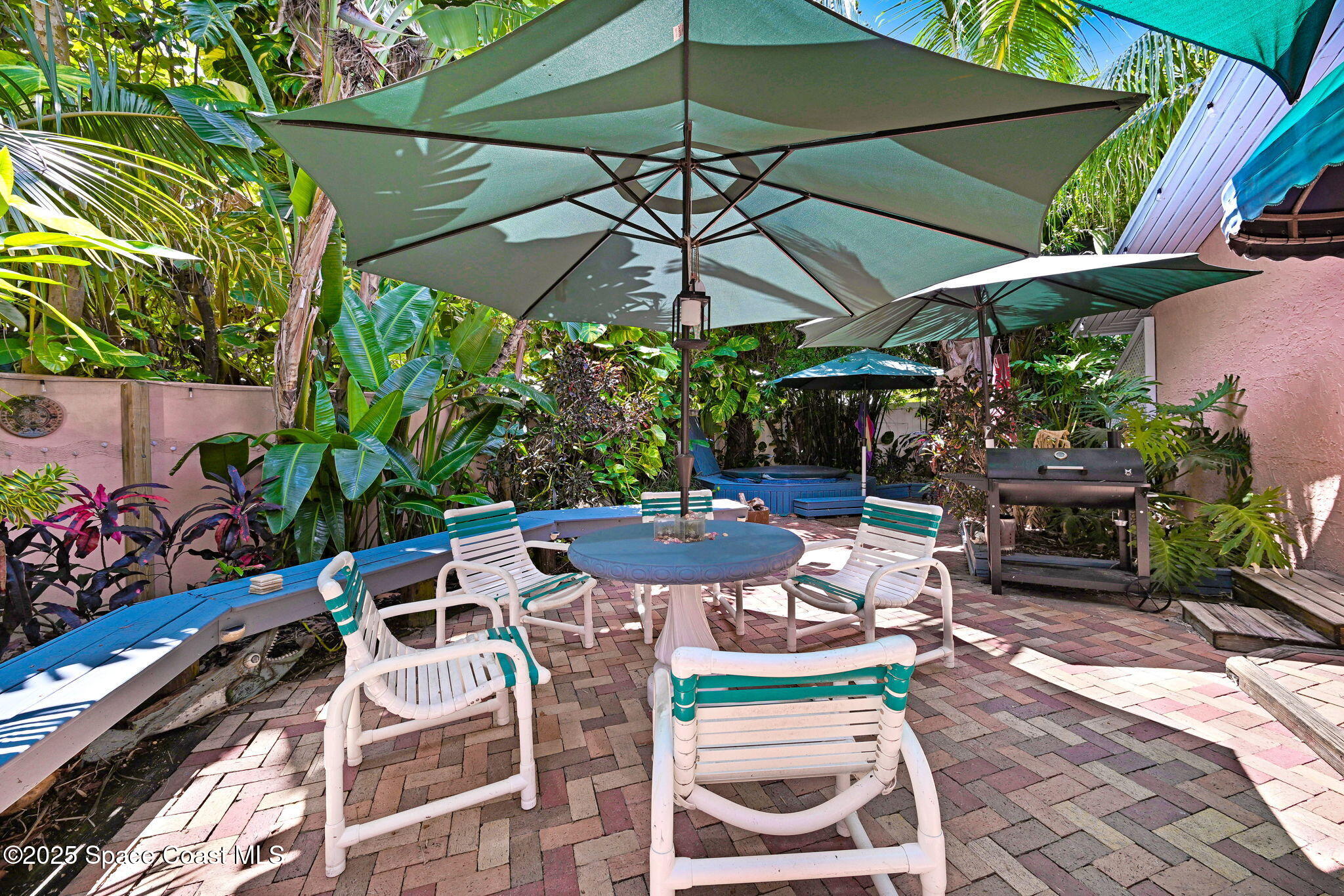 312 Wave Crest Avenue Indialantic, FL 32903 - Photo 21 of 62 a view of a patio with table and chairs under an umbrella