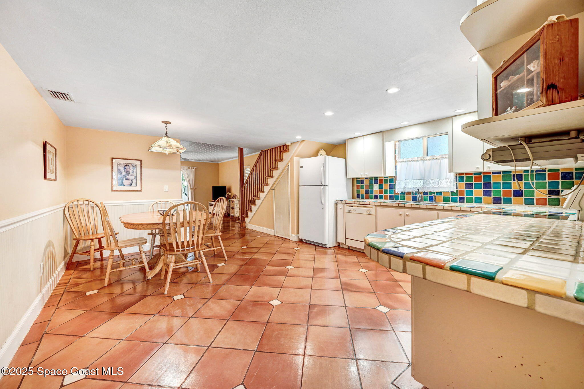 312 Wave Crest Avenue Indialantic, FL 32903 - Photo 37 of 62 a open kitchen with stainless steel appliances kitchen island granite countertop a table and chairs in it
