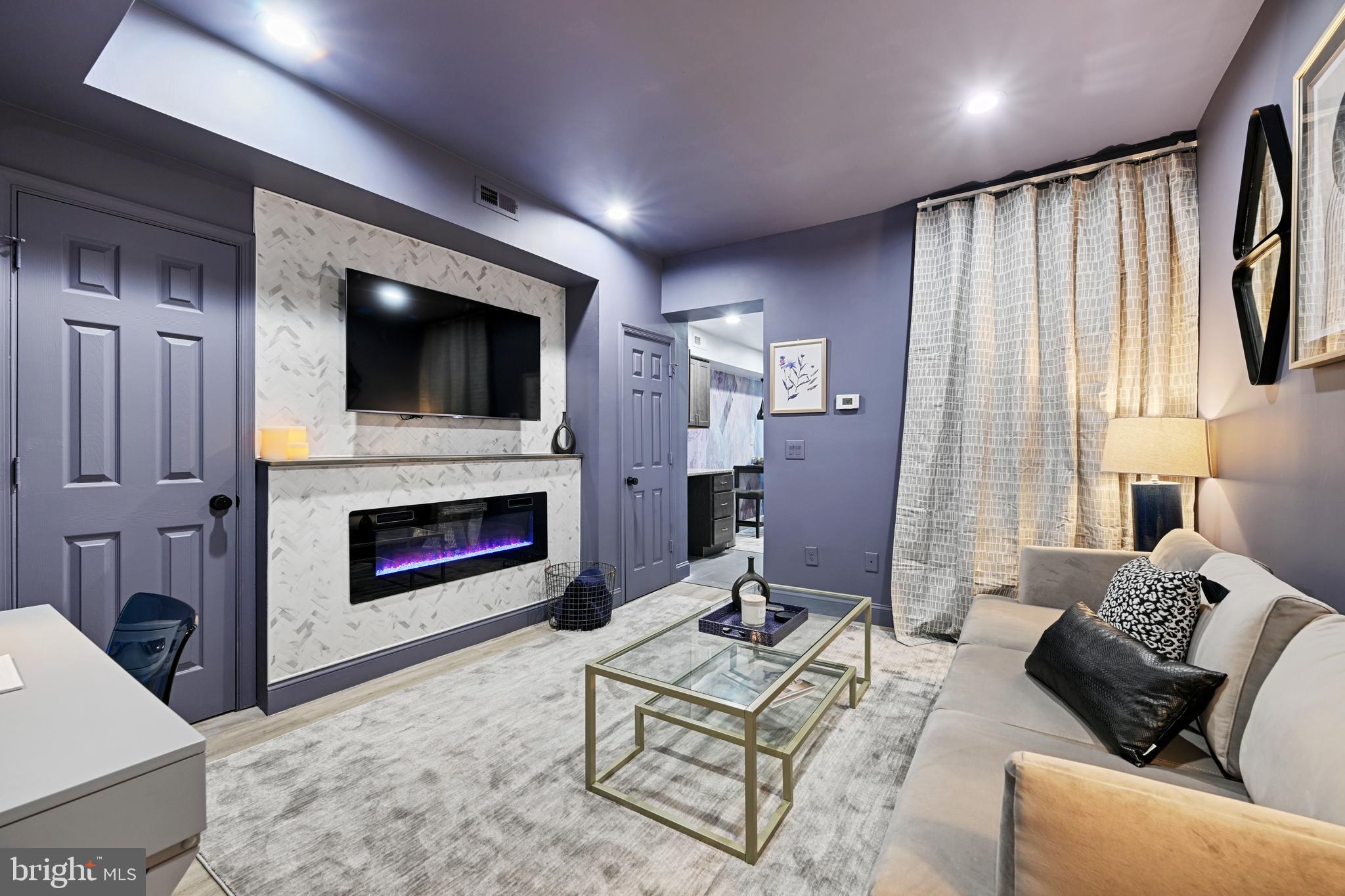 1709 Bank Street Baltimore, MD 21231 - Photo 26 of 49 a living room with furniture a fireplace and a flat screen tv