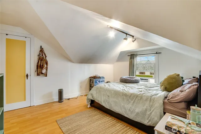 a bedroom with a bed and wooden floor