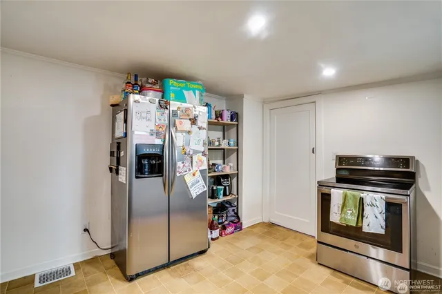 a kitchen with stainless steel appliances granite countertop a refrigerator and a stove
