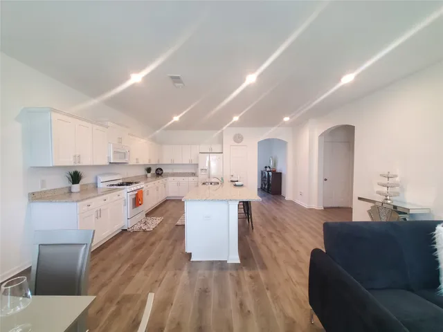 a living room with stainless steel appliances kitchen island granite countertop furniture and a kitchen view