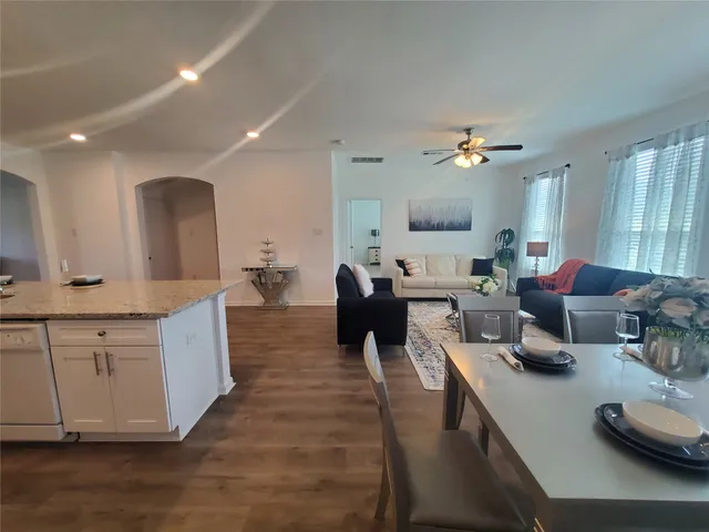 a living room with furniture kitchen and a chandelier