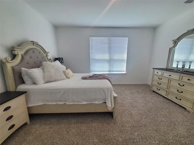 a bedroom with a bed and a dresser