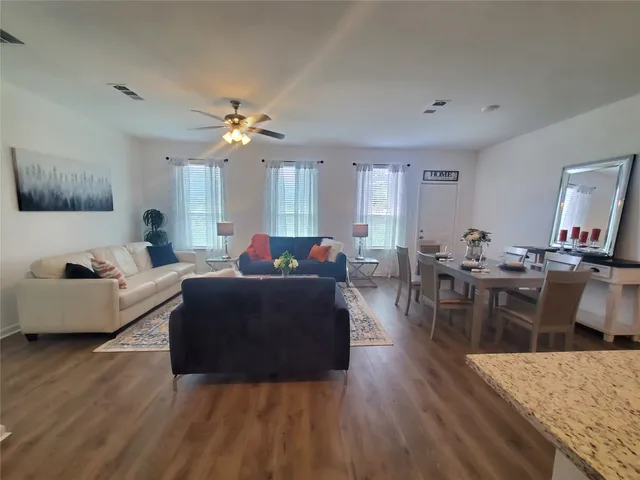 a living room with furniture a flat screen tv and a large window
