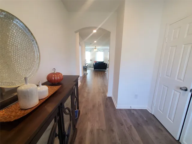 a view of a hallway with furniture and wooden floor
