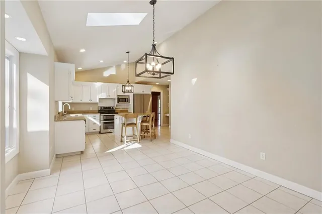 a view of kitchen with stainless steel appliances kitchen island microwave and cabinets