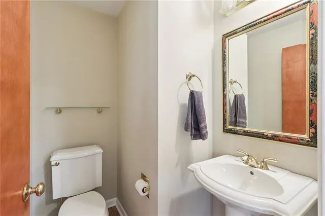 a bathroom with a toilet a sink and mirror