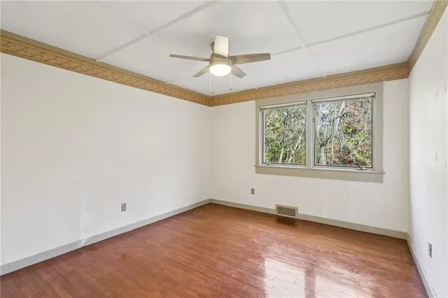 an empty room with a window and ceiling fan
